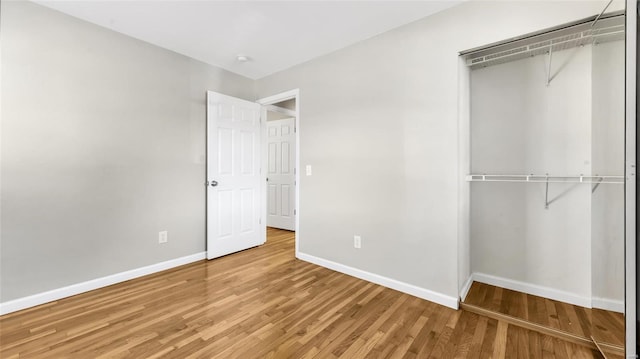 unfurnished bedroom featuring a closet, baseboards, and wood finished floors