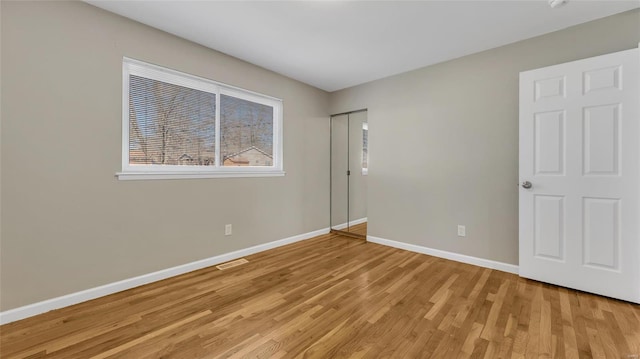 unfurnished bedroom featuring visible vents, light wood-style flooring, and baseboards