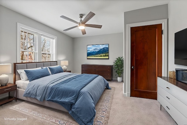 bedroom with light carpet, ceiling fan, and baseboards