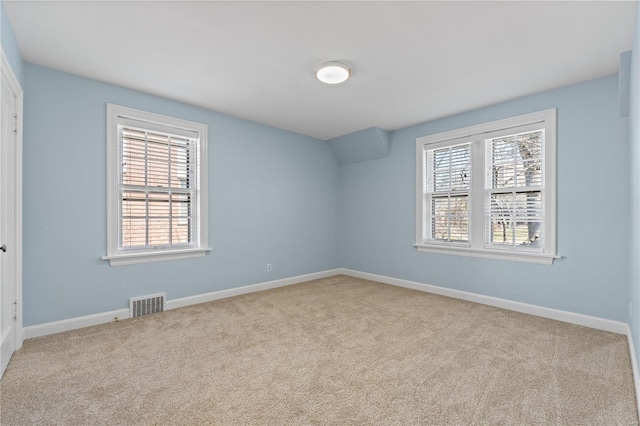 carpeted empty room featuring baseboards and visible vents