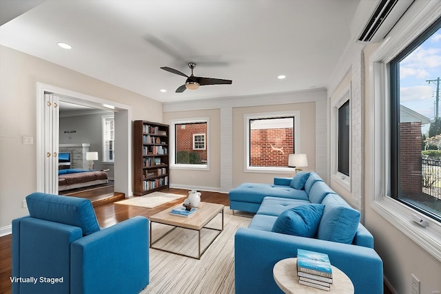 living area with recessed lighting, a fireplace, baseboards, and wood finished floors