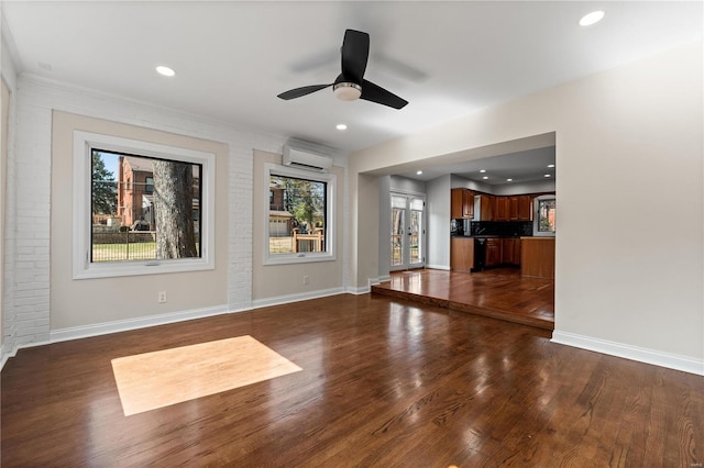 unfurnished living room with brick wall, baseboards, dark wood finished floors, and a wall mounted air conditioner