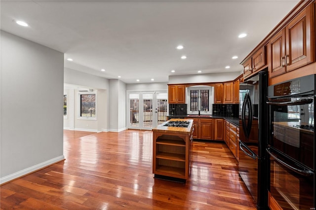 kitchen with hardwood / wood-style flooring, open shelves, french doors, decorative backsplash, and black appliances