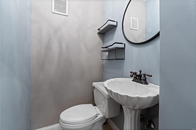 bathroom with visible vents and toilet