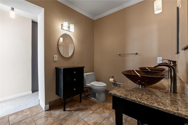 bathroom featuring toilet, baseboards, ornamental molding, and vanity