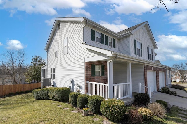 view of property exterior with a porch, fence, a yard, concrete driveway, and brick siding