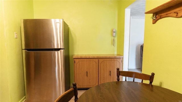 kitchen with freestanding refrigerator and brown cabinets