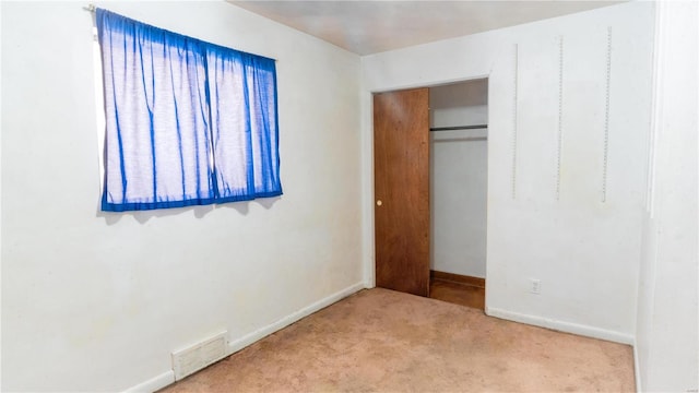 unfurnished bedroom with carpet floors, a closet, visible vents, and baseboards