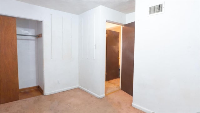 unfurnished bedroom with a closet, carpet flooring, visible vents, and baseboards