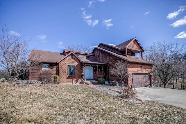 chalet / cabin with driveway, an attached garage, and a front yard