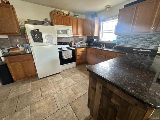 kitchen with white appliances, brown cabinets, a sink, and decorative backsplash