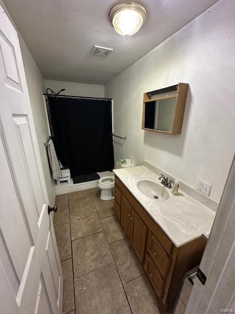 bathroom with curtained shower, visible vents, toilet, vanity, and tile patterned floors