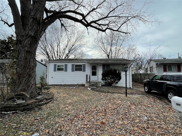 view of front of property featuring a garage, driveway, and fence