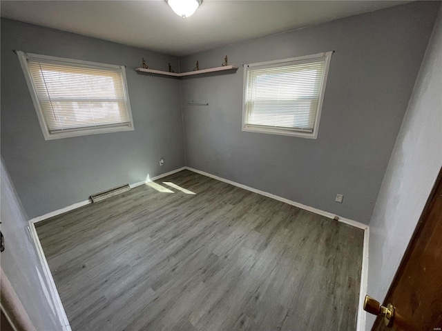 unfurnished bedroom featuring wood finished floors, visible vents, and baseboards