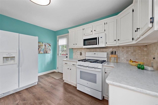 kitchen with dark wood-type flooring, white appliances, white cabinetry, and backsplash