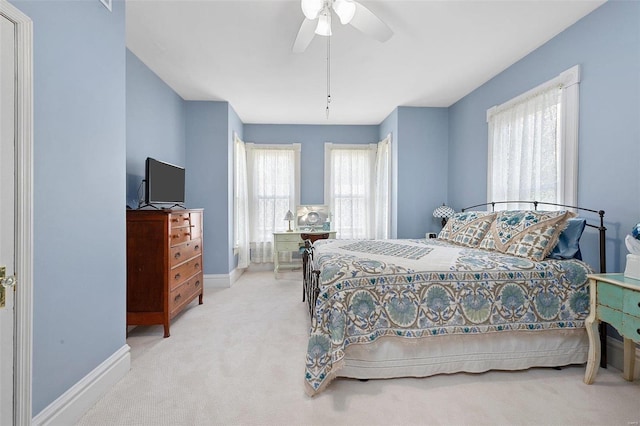 carpeted bedroom with a ceiling fan and baseboards