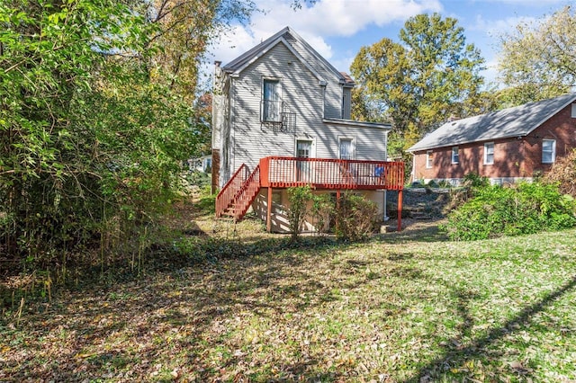 rear view of property featuring stairs, a lawn, and a wooden deck