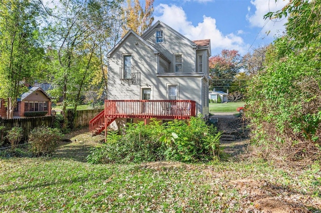 rear view of property with stairway, a wooden deck, and fence