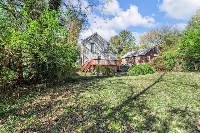 rear view of property with a lawn, a deck, and stairs