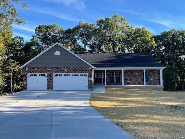 single story home featuring brick siding, a porch, an attached garage, driveway, and a front lawn