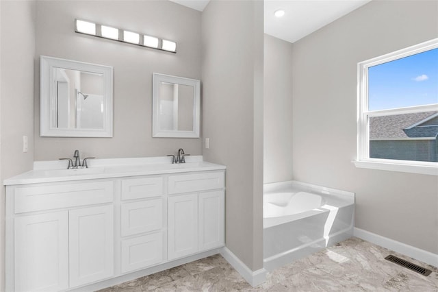 full bathroom featuring a bath, baseboards, visible vents, and a sink