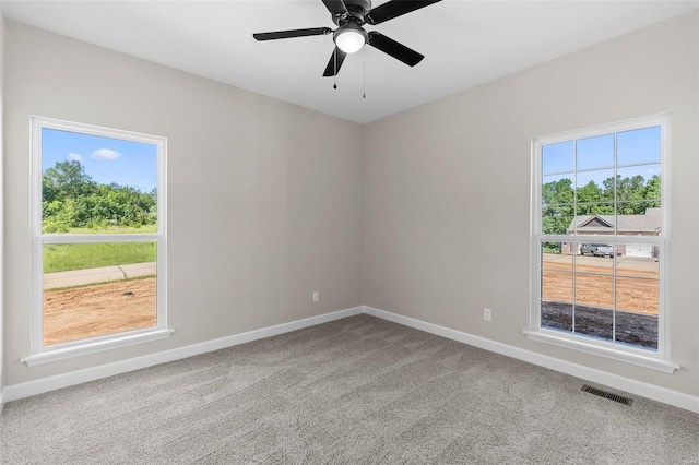 unfurnished room with ceiling fan, carpet flooring, visible vents, and baseboards