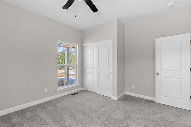 unfurnished bedroom featuring carpet floors, visible vents, baseboards, and a closet