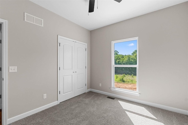 unfurnished bedroom featuring carpet, visible vents, and baseboards