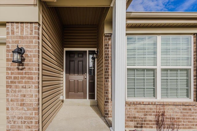 doorway to property featuring brick siding