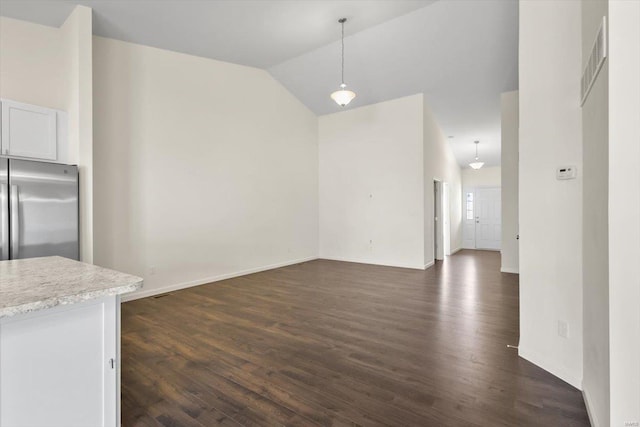 unfurnished dining area featuring lofted ceiling, dark wood-style flooring, visible vents, and baseboards