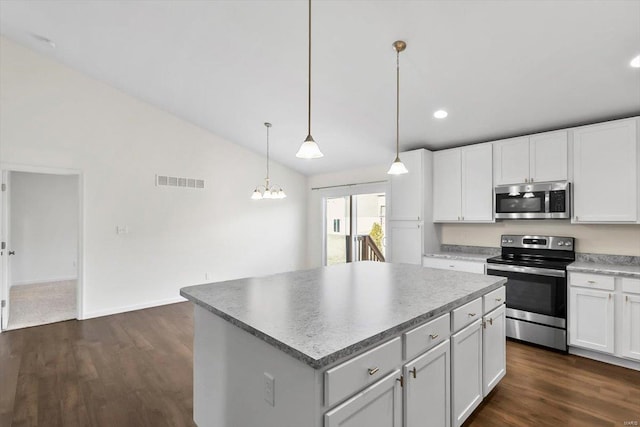 kitchen with visible vents, lofted ceiling, a kitchen island, appliances with stainless steel finishes, and dark wood-style flooring