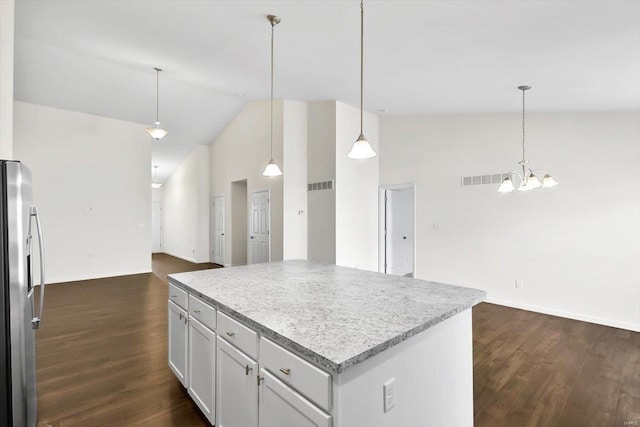 kitchen with dark wood-style floors, freestanding refrigerator, a center island, and light countertops