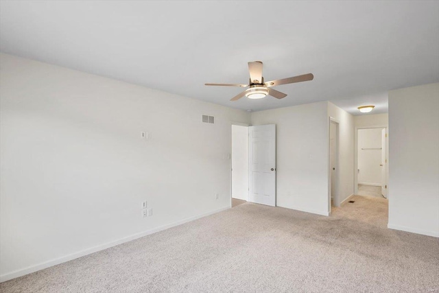 unfurnished room featuring baseboards, a ceiling fan, visible vents, and light colored carpet