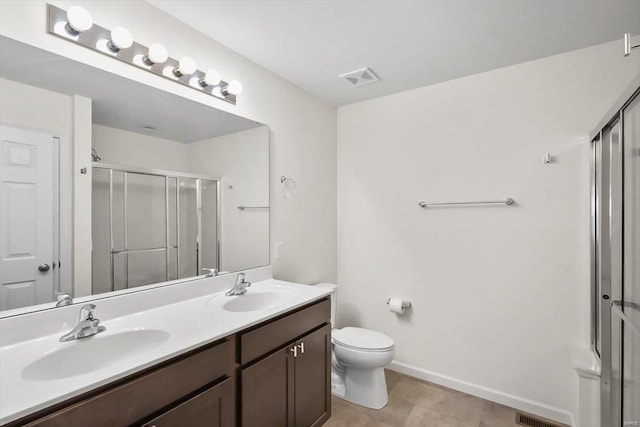 bathroom with toilet, a stall shower, a sink, and visible vents