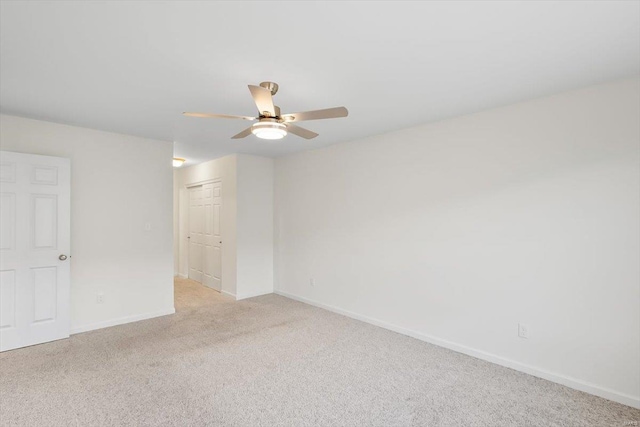 unfurnished room featuring light carpet, ceiling fan, and baseboards