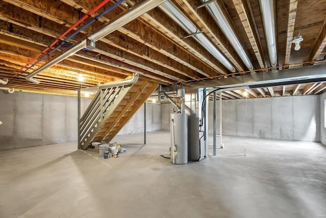 unfinished below grade area featuring stairs and gas water heater