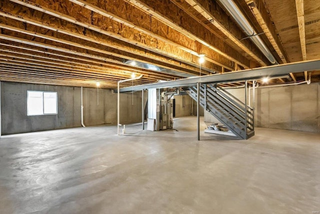 basement featuring heating unit and stairs