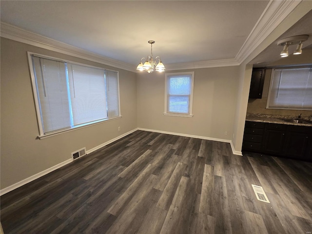 unfurnished dining area with dark wood-style floors, visible vents, crown molding, and a sink