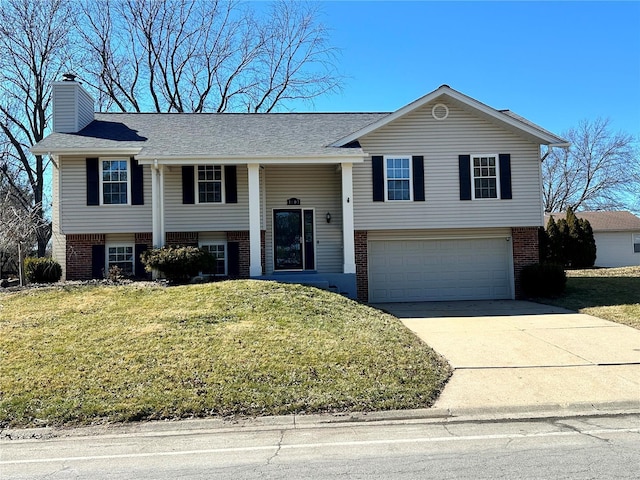 raised ranch with a front yard, brick siding, and driveway