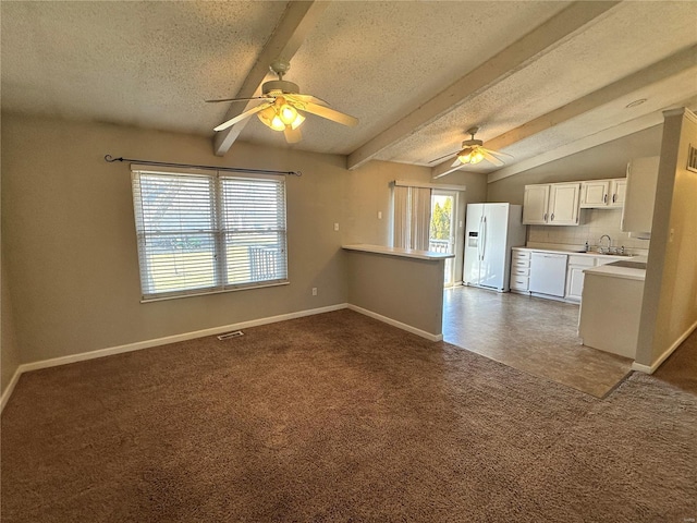 interior space featuring vaulted ceiling with beams, white appliances, dark carpet, and a ceiling fan