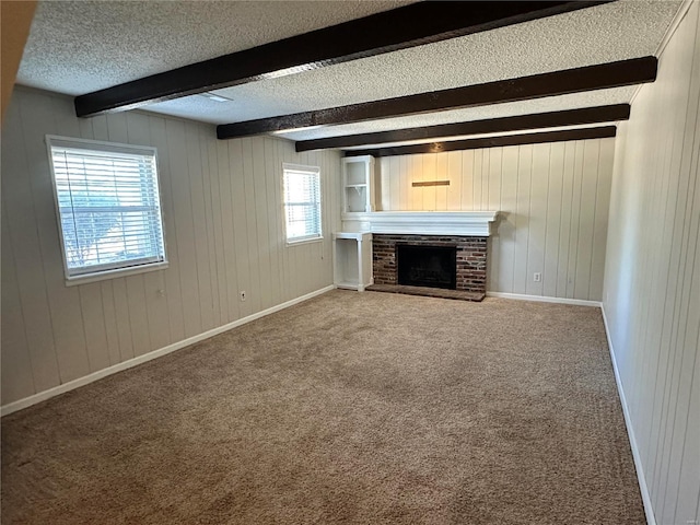 unfurnished living room with baseboards, beamed ceiling, a textured ceiling, carpet flooring, and a fireplace