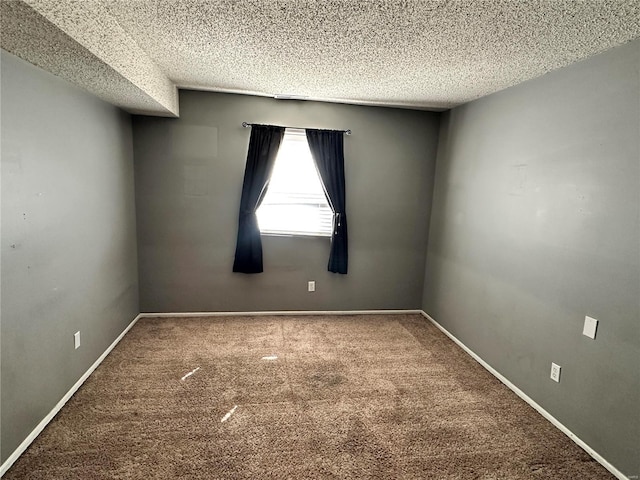 carpeted empty room featuring a textured ceiling and baseboards