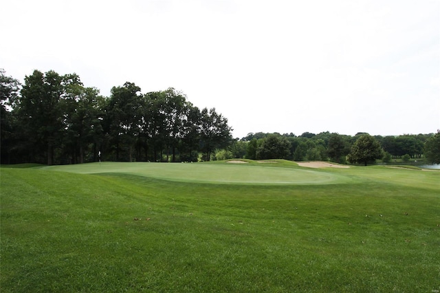 view of home's community with view of golf course and a yard