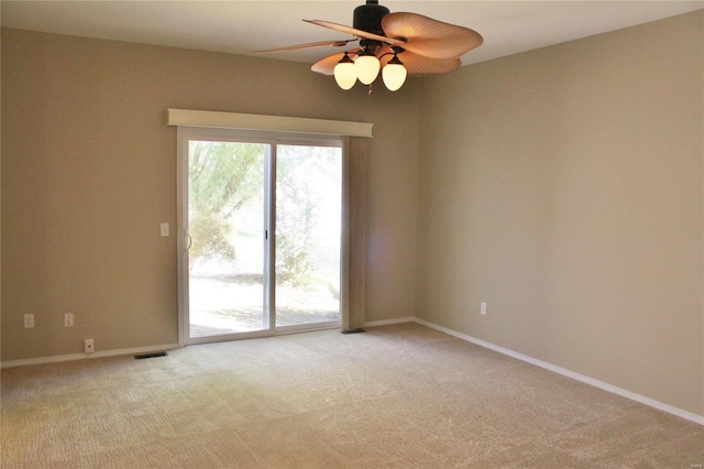 unfurnished room with baseboards, ceiling fan, visible vents, and light colored carpet