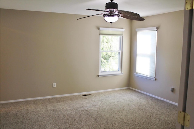 carpeted empty room featuring ceiling fan, visible vents, and baseboards