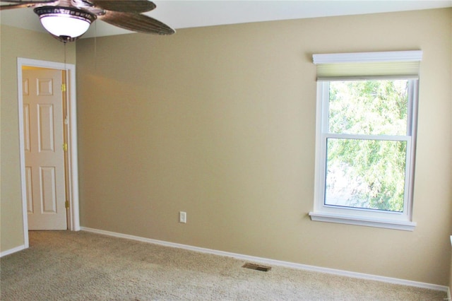 carpeted empty room with ceiling fan, visible vents, and baseboards