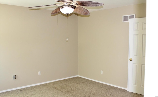 carpeted empty room featuring baseboards, visible vents, and a ceiling fan