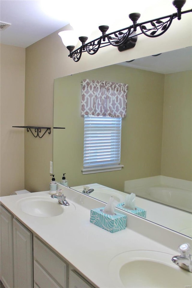 full bathroom featuring double vanity, visible vents, and a sink