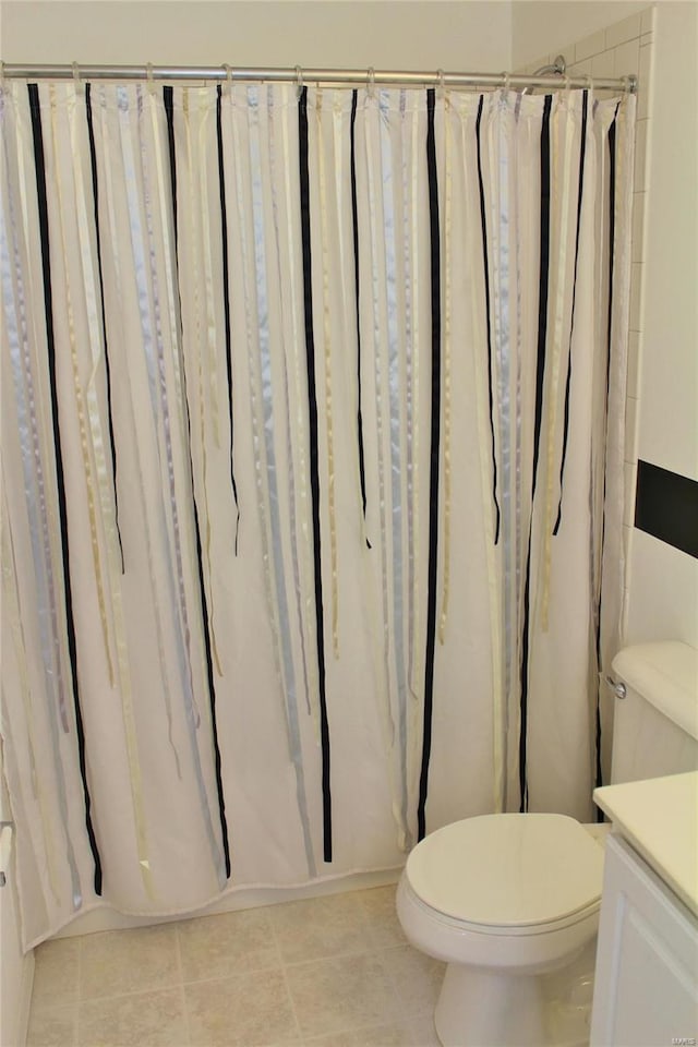 bathroom with curtained shower, vanity, toilet, and tile patterned floors