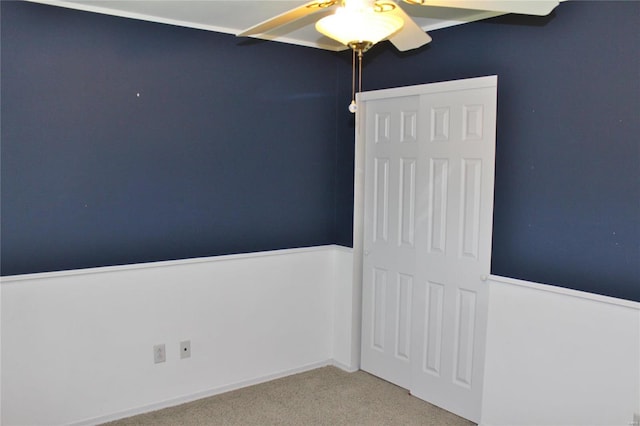 unfurnished bedroom featuring a ceiling fan, a closet, and carpet flooring